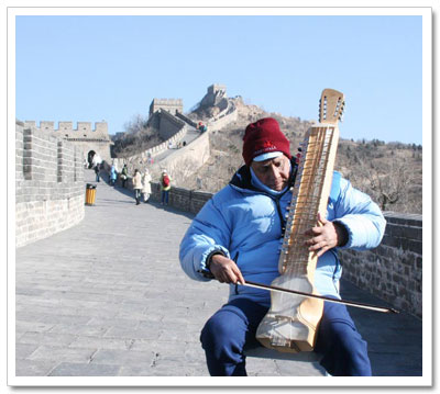 Sri Chinmoy playing esraj on the Great Wall of China near Bejing